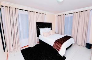 a bedroom with a bed with pink curtains at Goshen villas in Mbabane