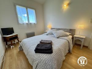 a bedroom with a bed and a desk and a television at Entre mer et village in Leucate