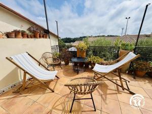 a patio with chairs and a table on a balcony at Entre mer et village in Leucate