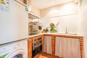 a kitchen with a washer and a sink and a dishwasher at Petit Ca l'Andorrà in Vila-Sana