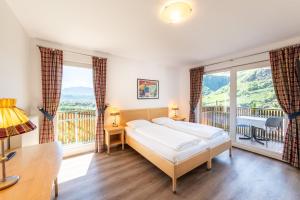 a bedroom with a bed and a balcony at Hotel Hanny Panoramic Views over Bolzano in Bolzano