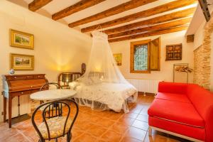 a bedroom with a bed and a red couch at Petit Ca l'Andorrà in Vila-Sana +16 photos