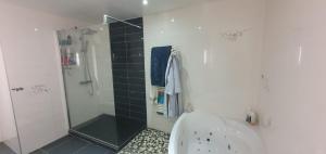 a white bathroom with a shower and a tub at Clos Pimi in Monbazillac