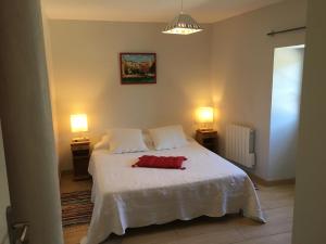 a bedroom with a white bed with two lamps at Clos Pimi in Monbazillac