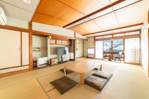 a living room with a table and a tv at 湯宿ささくら in Kinosaki
