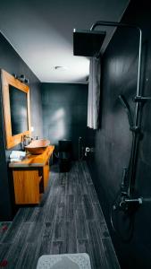 a black bathroom with a sink and a toilet at Skojet Boutique Hotel in Ruhengeri