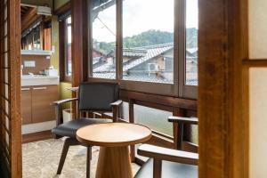 a room with a table and chairs and a large window at 湯宿ささくら in Kinosaki +24 photos