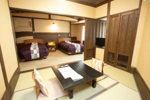 a room with a dining table and a bedroom at お宿玄河 in Minamioguni