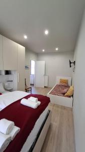 a white bedroom with a bed and a couch at Risorgimento 8 appartamento centro Santa Maria Maggiore Valle Vigezzo in Santa Maria Maggiore