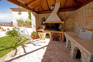 an outdoor kitchen with a stove and a stone wall at Aphrodite's House in Porto Heli