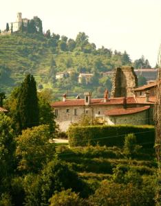 un grupo de edificios en una colina con una casa en Castello di Cernusco Lombardone, en Cernusco Lombardone