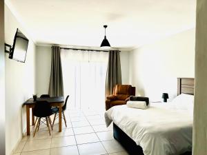 a bedroom with a bed and a desk and a chair at ValView Guest Lodge in Thabazimbi