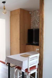 a dining room with a table and a tv at L'Eden maison avec jardin proche du Puy dufou in Les Landes-Génusson