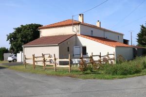 a white building with a fence in front of it at L'Eden maison avec jardin proche du Puy dufou in Les Landes-Génusson