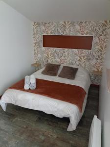 a bedroom with a large bed with two pillows at L'Eden maison avec jardin proche du Puy dufou in Les Landes-Génusson