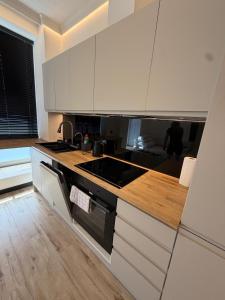 a kitchen with white cabinets and a stove top oven at Apartament Ania Nysa Centrum z bezpłatnym parkingiem in Nysa +4 photos