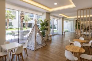 a dining room with tables and chairs and windows at Casa Arena Rosa in Jávea