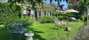 a group of chairs sitting in a yard at Noardlik B&B in Birdaard