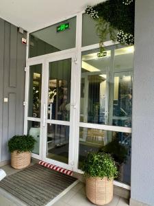 a store entrance with two potted plants in front of it at Hotel Dolynskiy in Lviv