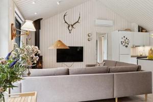 a living room with a couch and a tv at Nordic Nature Hideaway in Yderby