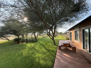 a wooden bench sitting on a porch next to a yard at ValView Guest Lodge in Thabazimbi