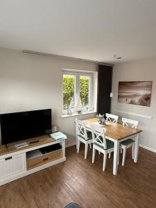 a living room with a dining room table and a television at Ferienhaus SPO 54 grad in Böhl