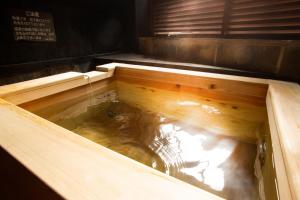 a wooden bathtub with water in it in a room at お宿玄河 in Minamioguni +6 photos