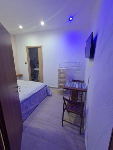 a bedroom with a bed and a table and a television at Il Faro Suites in Taranto