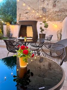 a patio with chairs and a table with a vase with flowers at Hotel Dolynskiy in Lviv