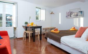 リスボンにあるBombarda Studioのベッド、テーブル、ソファが備わるホテルルームです。