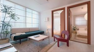 a living room with a green couch and a mirror at SOYO-SOOP Stay in Seoul