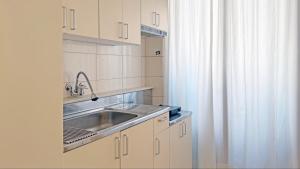a kitchen with a sink and a shower curtain at SOYO-SOOP Stay in Seoul