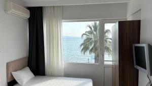 a bedroom with a window with a view of the ocean at Grand Erdek Hotel in Erdek