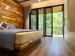 a bedroom with a bed and a wooden wall at Suối Mộc Ecostay - Mộc Châu in Mộc Châu
