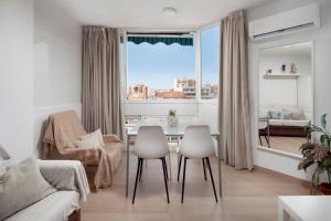 a living room with a table and chairs and a window at Sol y breeze in Torre del Mar