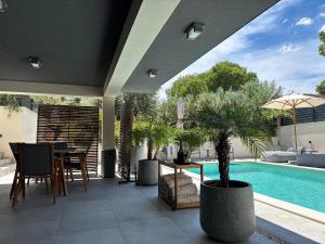 a patio with a table and chairs and a pool at DiDixi Apartments in Pakoštane