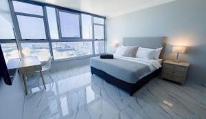 a bedroom with a bed and a desk and windows at Sea Esta On Beach in Strand