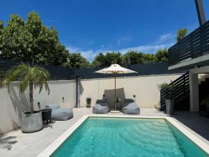 a swimming pool with an umbrella and a palm tree at DiDixi Apartments in Pakoštane