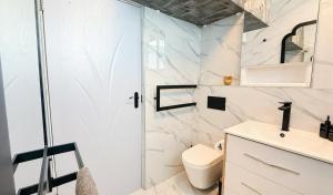 a bathroom with a shower and a toilet and a sink at Sea Esta On Beach in Strand +16 photos
