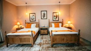 a bedroom with two beds and two lamps on the wall at Skojet Boutique Hotel in Ruhengeri