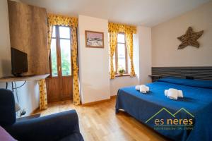 a bedroom with a blue bed and a tv at Casa Es Neres in Les