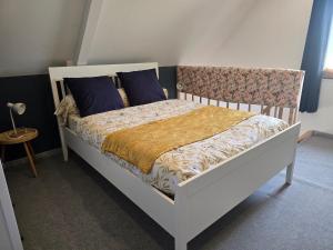 a bedroom with a white bed with blue pillows at A la folie in Folligny
