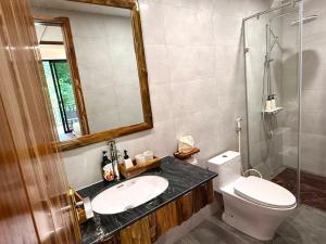 a bathroom with a sink and a toilet and a mirror at Suối Mộc Ecostay - Mộc Châu in Mộc Châu