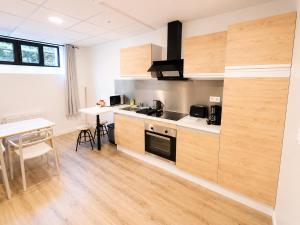 a kitchen with wooden cabinets and a table in a room at Studio des quais in Saint-Aignan