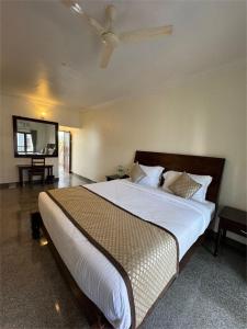 a bedroom with a large bed with a tv on the wall at Moringa Stays Formerly Deep International in Mandrem