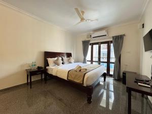 a bedroom with a bed and a large window at Moringa Stays Formerly Deep International in Mandrem