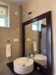 a bathroom with a sink and a mirror at Moringa Stays Formerly Deep International in Mandrem