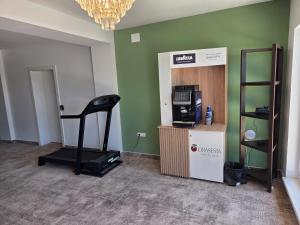 a room with a gym with a treadmill and a television at FLORA Garden Relax in Filiaşi