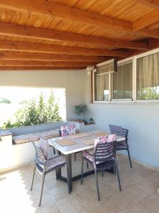 a patio with a table and chairs under a wooden ceiling at komi's family house in Kómi