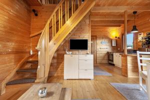 a living room with a staircase in a log cabin at Ferienhaus Sonne in Hohnstein